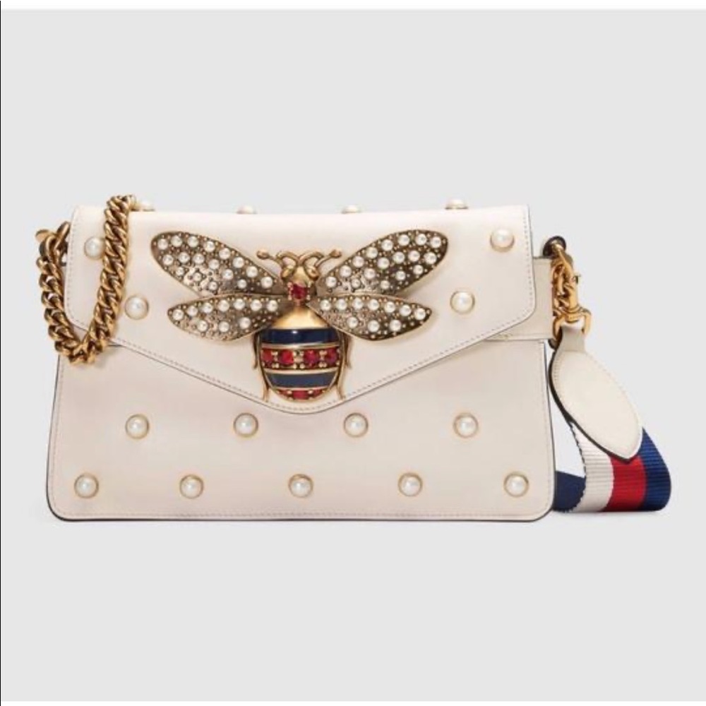 clutch all over pearl studs and metal bee detail.